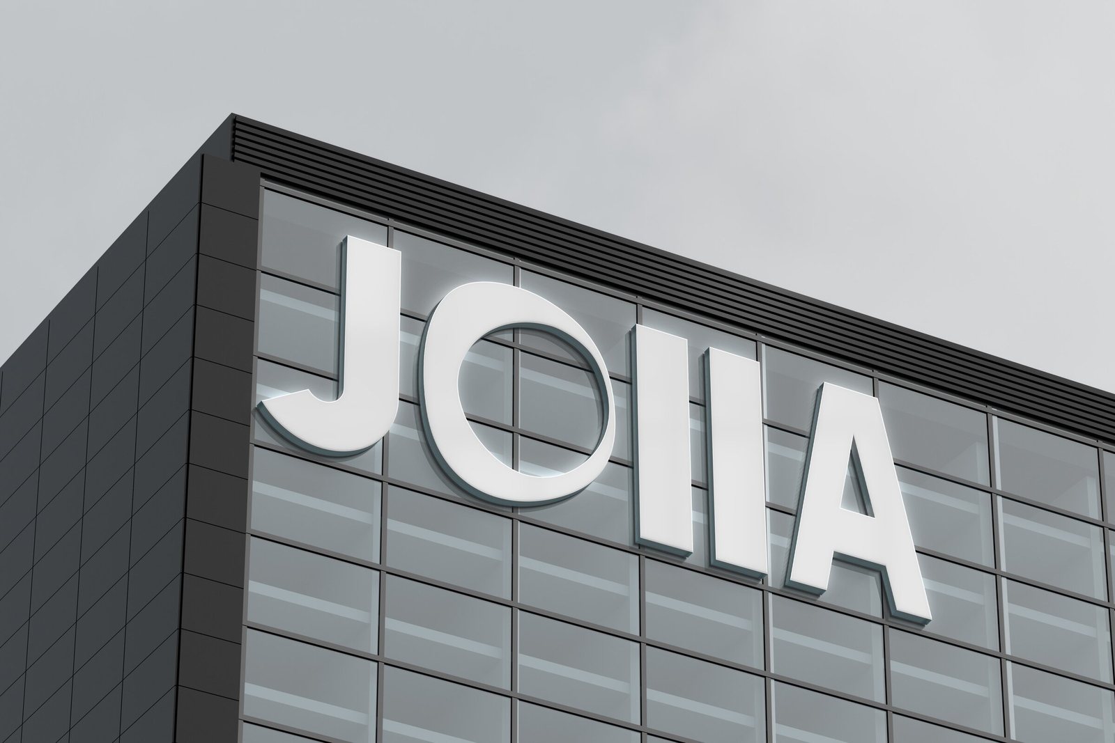 Lettres Joiia en relief sur la façade grise d'un immeuble