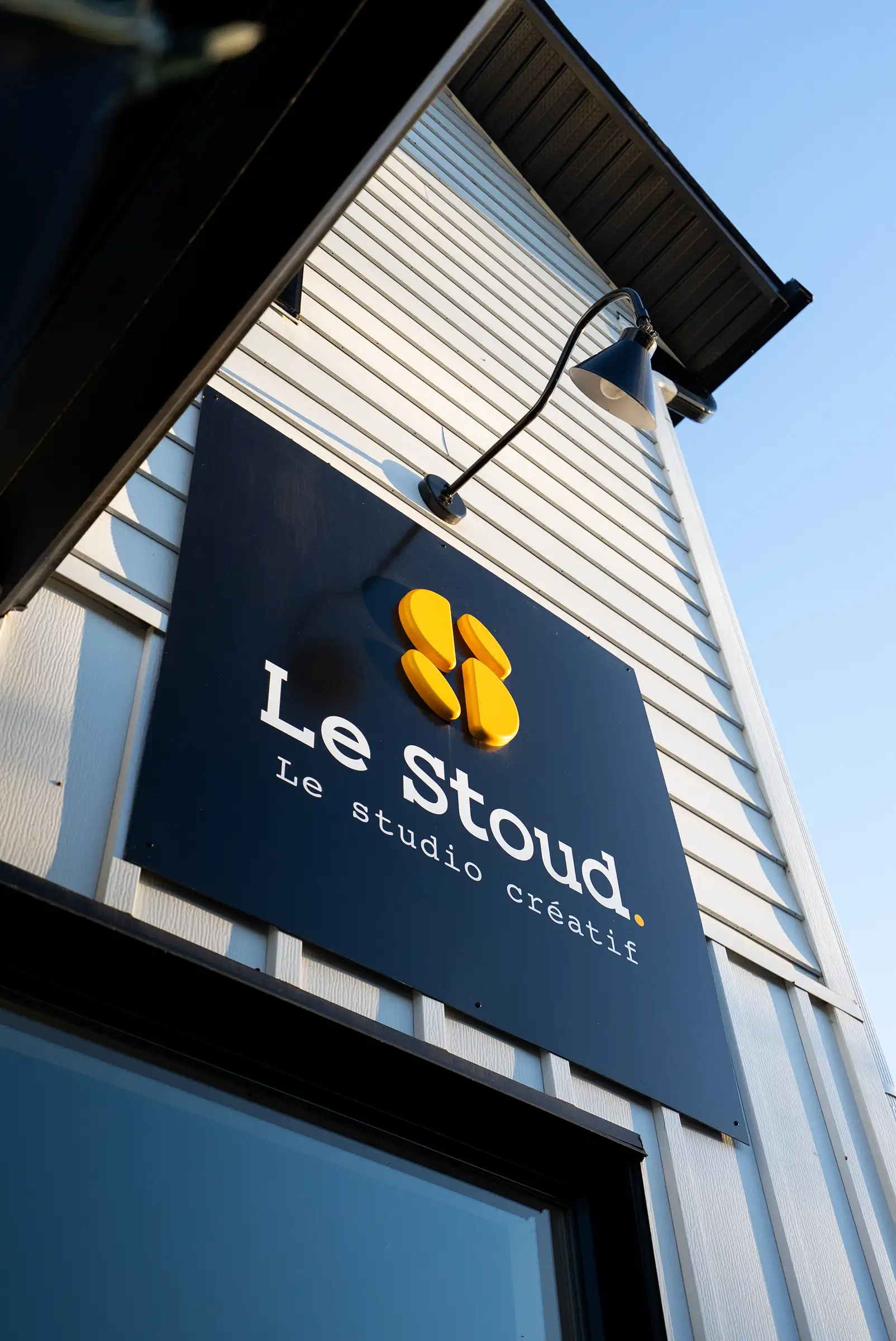 L'enseigne du Stoud, le studio créatif, sur la façade, sous un ciel bleu
